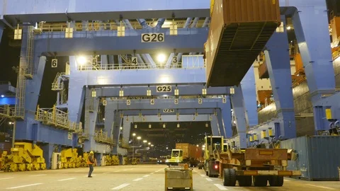 Containers being transferred at night from ship at the container terminal 4k Stock Footage 88951055