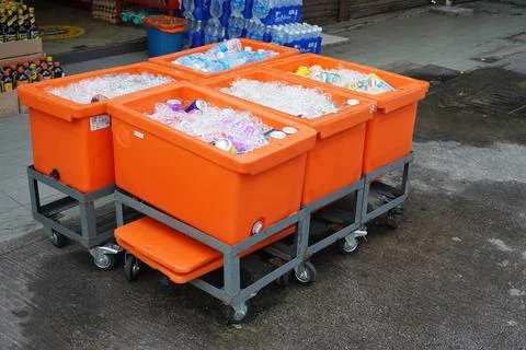 Containers filled with ice cubes and drink bottles in front of the shop Stock Photos