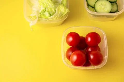 Containers with fresh vegetables on a yellow background Stock Photos