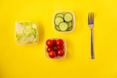 Containers with fresh vegetables on a yellow background Stock Photos
