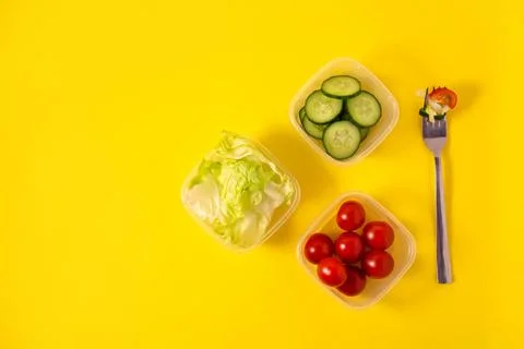 Containers with fresh vegetables on a yellow background Stock Photos