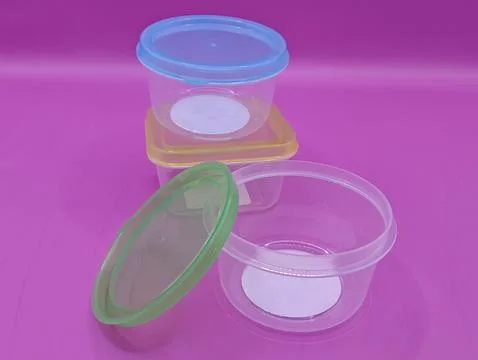 Containers with lids on a purple background Stock Photos