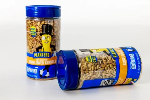 Containers of roasted sunflower kernels displayed on clean surface in well-lit Stock Photos