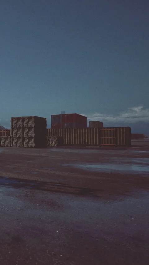 Containers sit quietly on the shore under a vast blue sky at twilight Stock Footage 331697490