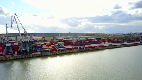 Containers, train and cargo cranes in Seville fluvial harbor, and runway Stock Footage 147634449