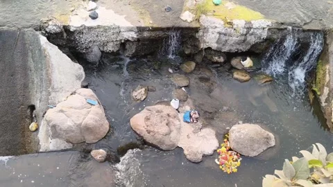 Contaminated Stream Water Flowing Through Rocks With Trashes 库存影片 330325911