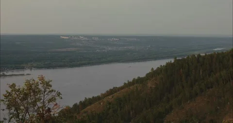 Contemplating vast river landscape and distant city from mountain peak Stock Footage 307810961