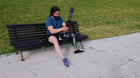 Contemplative Athlete Preparing His Prosthetic for a Workout in the Park Stock-Footage 264035499