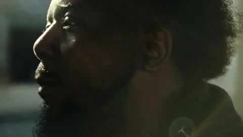 Contemplative black man's profile in sunlight Stock Footage 331599067