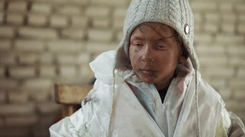 Contemplative Dirty Child in White Jacket and Wool Hat Indoors Stock Footage 317695934