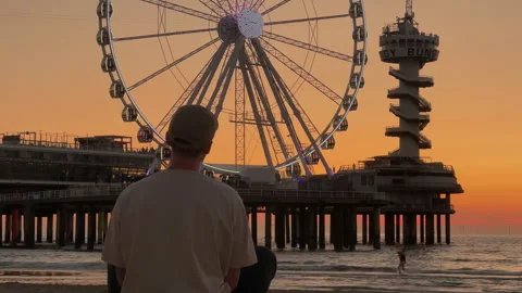 Contemplative Evening at the Beach with Scenic View of Ferris Wheel Vídeos de archivo 295994410