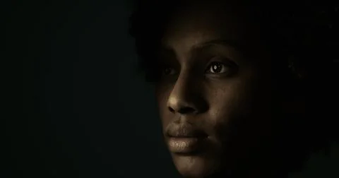 Contemplative expression and soft light on face in a dim background Illustrazione stock