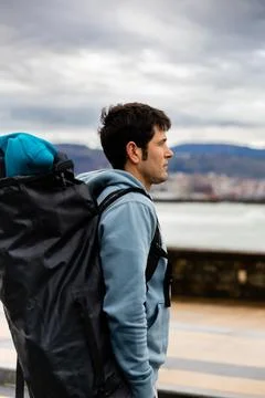 Contemplative man with backpack overlooking the sea, copy space, Stock Photos
