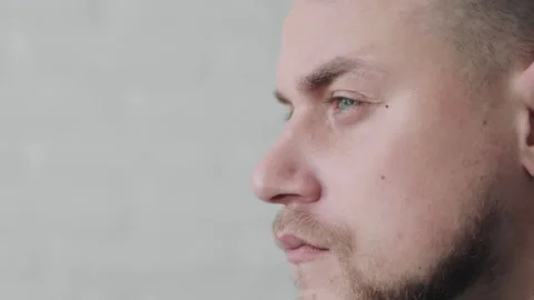 Contemplative Man Close-up, Close-up side view of a thoughtful man with a Stock Footage 265145526