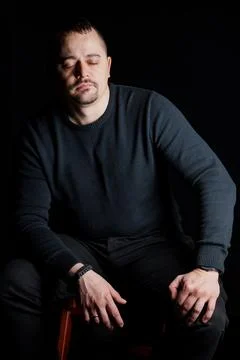 Contemplative Man in Dark Setting 스톡 사진