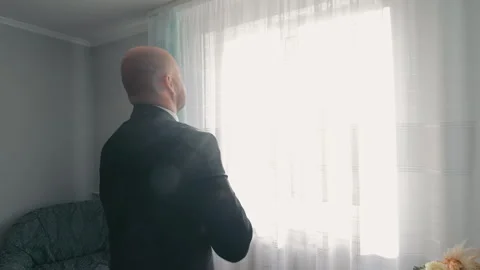 Contemplative Man Gazing Through Sheer Curtains, A bald man in a dark shirt Video stock 263193191