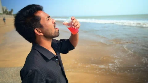 Contemplative Man Having Drink on the Beach Stock Footage 281320809