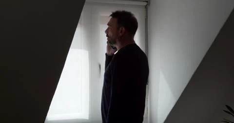 Contemplative Man Near Window: Stock Footage 331538543