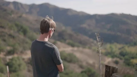 Contemplative man in rugged mountain landscape Stock Footage 143674960