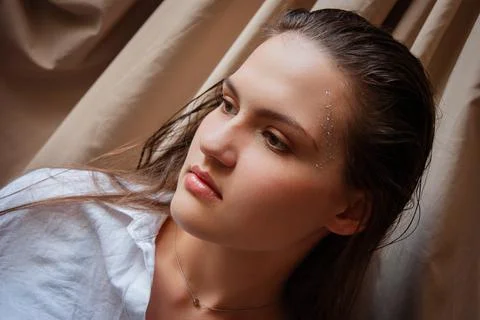 Contemplative portrait with subtle makeup and wet hair on neutral backgroun.. Stock Photos