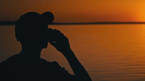 Contemplative Silhouette: Man Drinks Coffee At Sunset Stock Footage 275825083