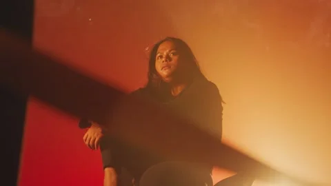 Contemplative Woman in Dramatic Lighting Stock Footage 296573809