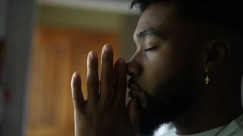 Contemplative young man praying to God An African America person prays Stock Footage 170312440