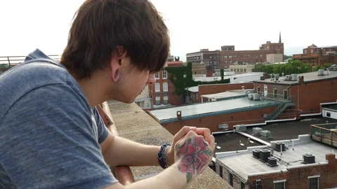 Contemplative young man thinking on top of building Stock Footage 90526471
