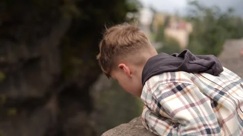 Contemplative Youth Sitting by the Tranquil Waters Edge, Embracing Natures Stock Footage 292803776