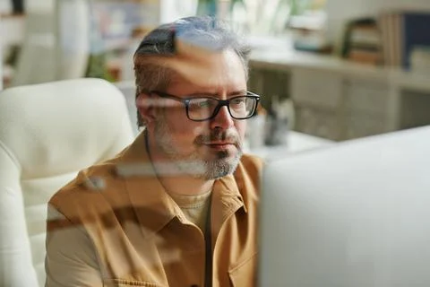 Contemporary aged programmer or IT engineer working in front of computer Stock-Fotos