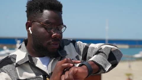Contemporary black guy is checking notifications in smartwatch, african man Stock Footage 231901507