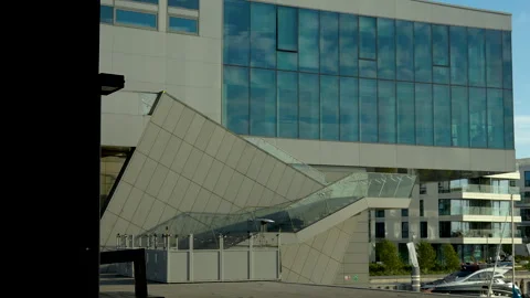 Contemporary building with angular glass facade in daylight. Vídeos de archivo 254547510