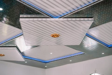 A contemporary ceiling featuring geometric panels, integrated lighting, and.. Stock Photos