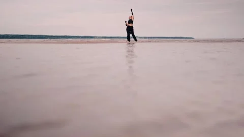 Contemporary dancer in black clothes dancing in the sea Stock Footage 265901226