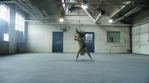 Contemporary dancer dances with passion and lots of energy in  warehouse 스톡 동영상 104457572