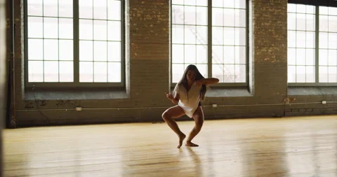 Contemporary dancer dancing in industrial brick and beam loft during daytime. Wi Stock Footage 199461671