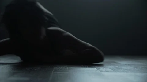 Contemporary dancer rolling on floor dancing in dark moody dance studio Vídeo Stock 104268882