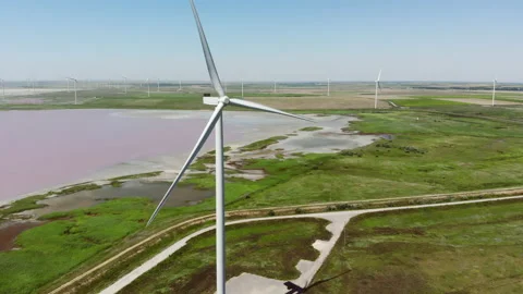 Contemporary energy generators stand on wind farm by lake Video stock 157802003