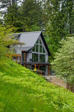 Contemporary A-Frame House front side on Forested Hillside Фото