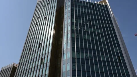 Contemporary glass skyscraper facade with sun reflection and blue sky Stock Footage 331582200