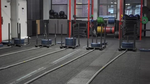A Contemporary Gym Interior Featuring Various Training Equipment and Sleds for Video stock 295009148