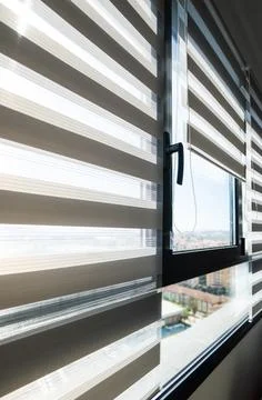 Contemporary interior window with zebra roller blinds and city view Foto stock