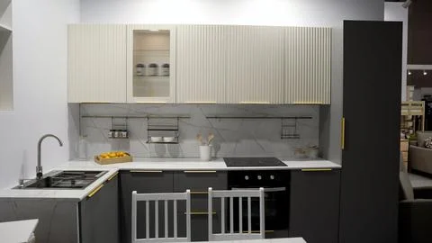 Contemporary kitchen design featuring dark grey and off-white fluted cabinets Foto stock