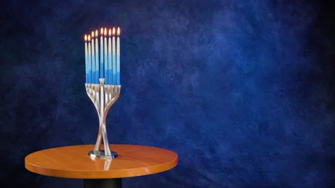 Contemporary Menorah initially rotating with all candles lit. Stock Footage 323127849