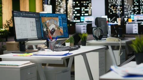 Contemporary office desk with CAD interface displaying digital blueprints Stockfoto's