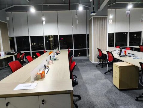 Contemporary Office Setup Featuring Red Chairs and Natural Night Lighting Stock Photos