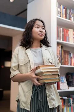 Contemporary student with stack of books Foto stock