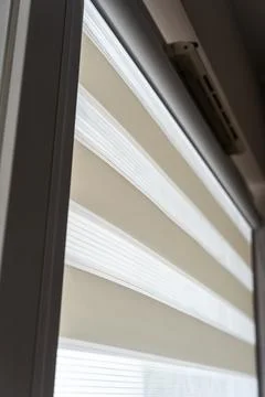 Contemporary window blinds featuring layered fabric design that provides elegant Stock Photos