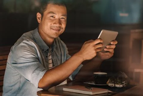 Content Asian man browsing online while sitting in a cafe Foto stock