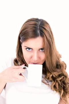 Content attractive brunette drinking from a cup in bright bedroom Stock Photos